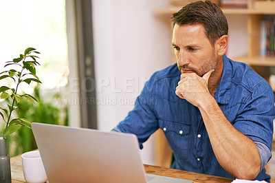 Buy stock photo Shot of a man working on his laptop at home