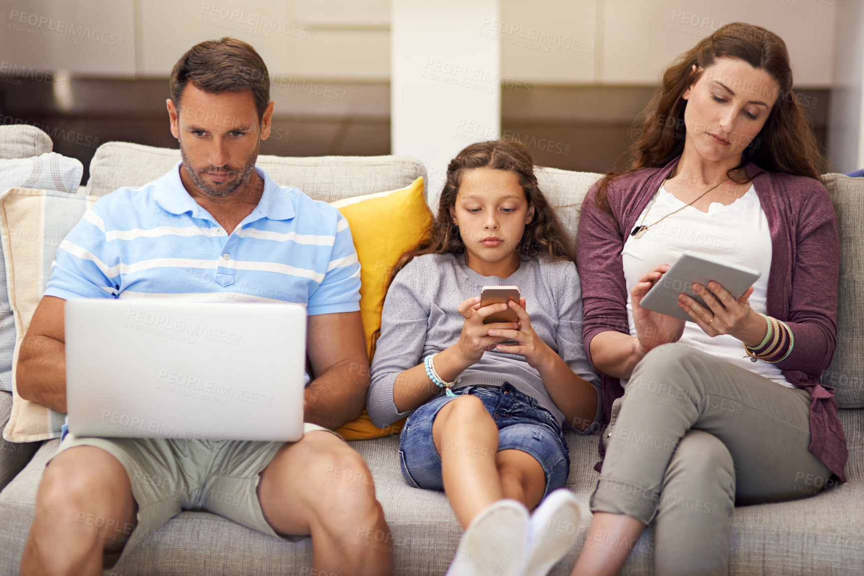Buy stock photo Cropped shot of a family sitting on the sofa at home