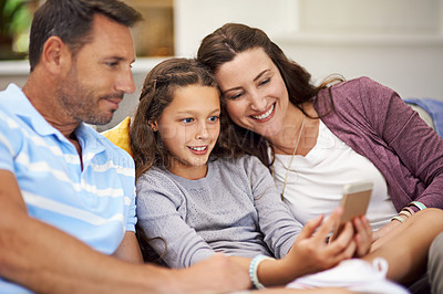 Buy stock photo Cropped shot of a family sitting on the sofa at home