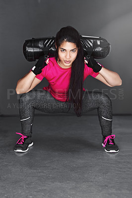 Buy stock photo Studio shot of an attractive young woman working out with dumbbells  against a gray background