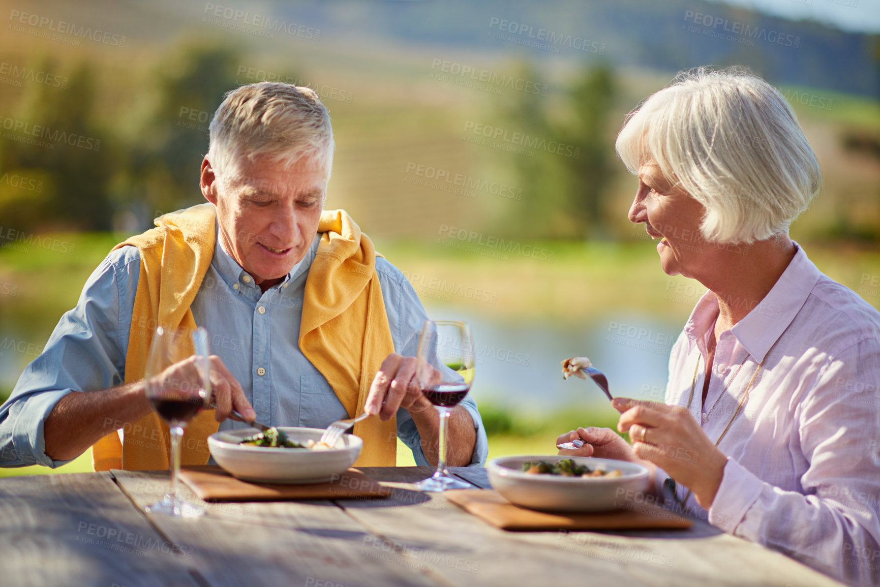 Buy stock photo Cropped shot of a senior couple drinking wine while enjoying a meal outdoors