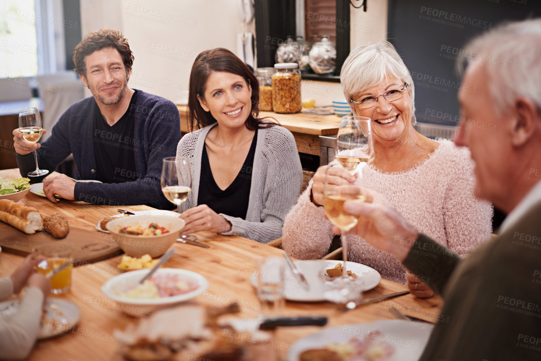 Buy stock photo Happy, cheers and people at dinner in dining room for party, celebration or event at modern home. Smile, bonding and group of family enjoying meal, supper or lunch together with wine at house.