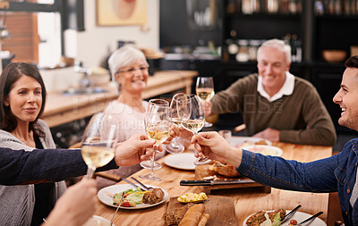 Buy stock photo Cheers, champagne and family at dinner in dining room for party, celebration or event at modern home. Smile, toast and group of people enjoying meal, supper or lunch together with wine at house.