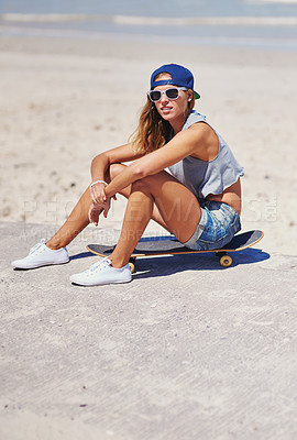 Buy stock photo Shot of a young woman at the beach with her skateboard