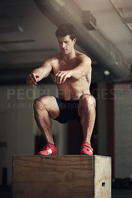 Buy stock photo Shot of a well built man doing squats at the gym