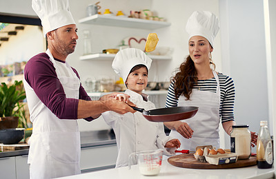 Buy stock photo Shot of a family of three baking together in the kitchen