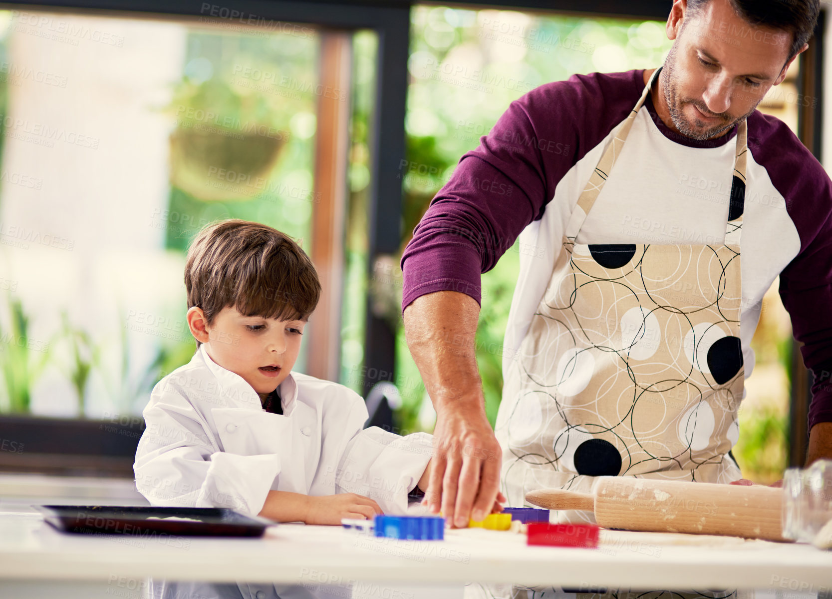 Buy stock photo Shot of a father and son baking biscuits in the kitchen