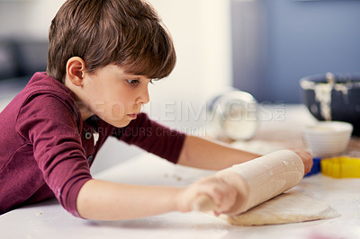 Buy stock photo Shot of a little boy rolling out dough in the kitchen