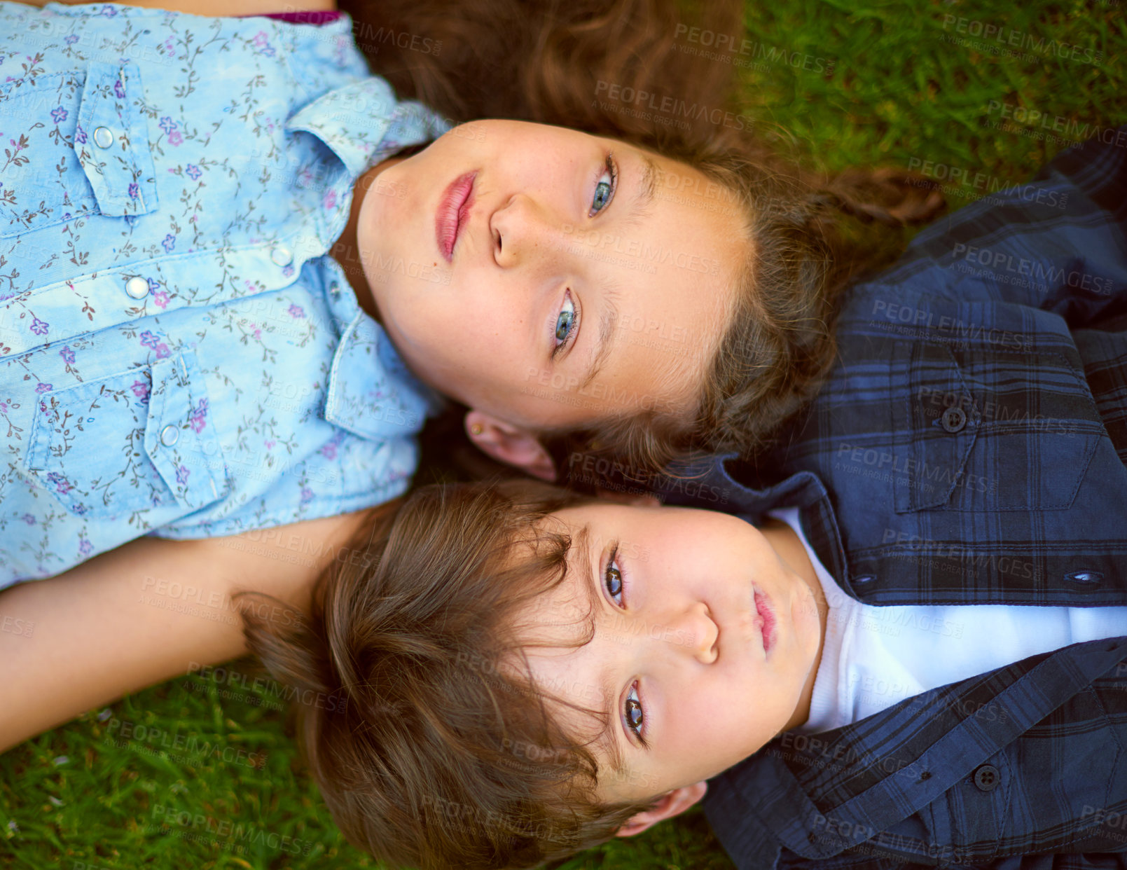 Buy stock photo Happy children, portrait and lying above with grass field for bonding, holiday or outdoor weekend in nature. Top view of little girl, boy or brother and sister on lawn in backyard for childhood 