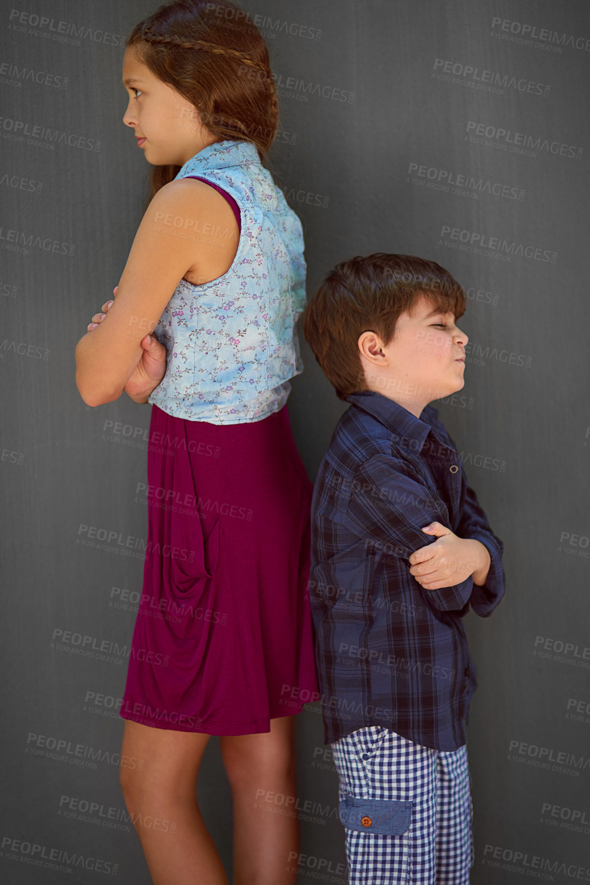 Buy stock photo Studio shot of a young brother and sister standing back to back against a gray background
