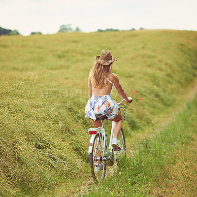 Buy stock photo Back view, bicycle or woman cycling in countryside for holiday, adventure or wellness to relax in nature. Field, explore or healthy girl on bike for eco friendly travel, carbon footprint or vacation