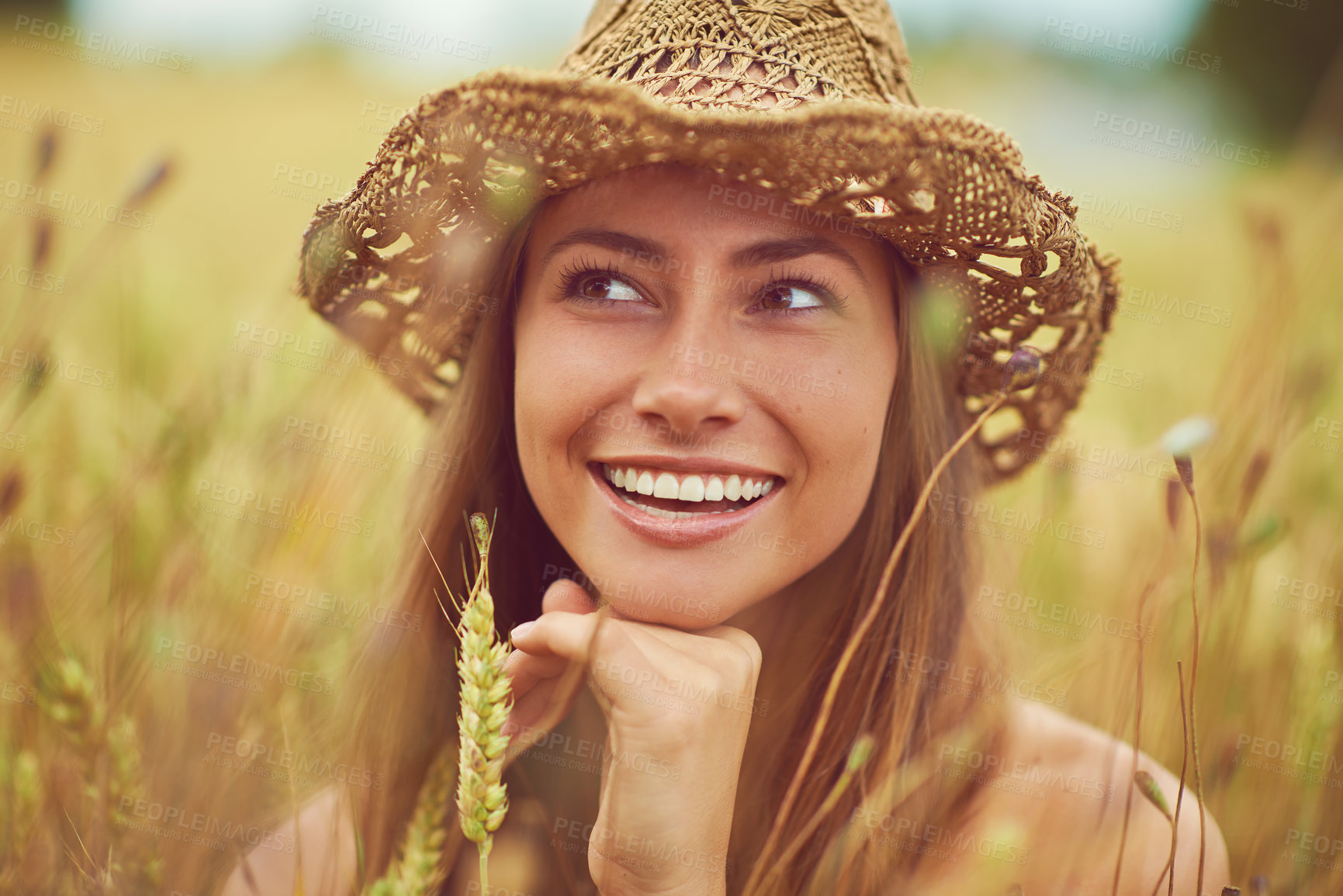 Buy stock photo Smile, thinking and wellness with woman in wheat field outdoor for holiday, travel or vacation in summer. Face, hat and relax with happy person in countryside or nature for calm or peaceful break