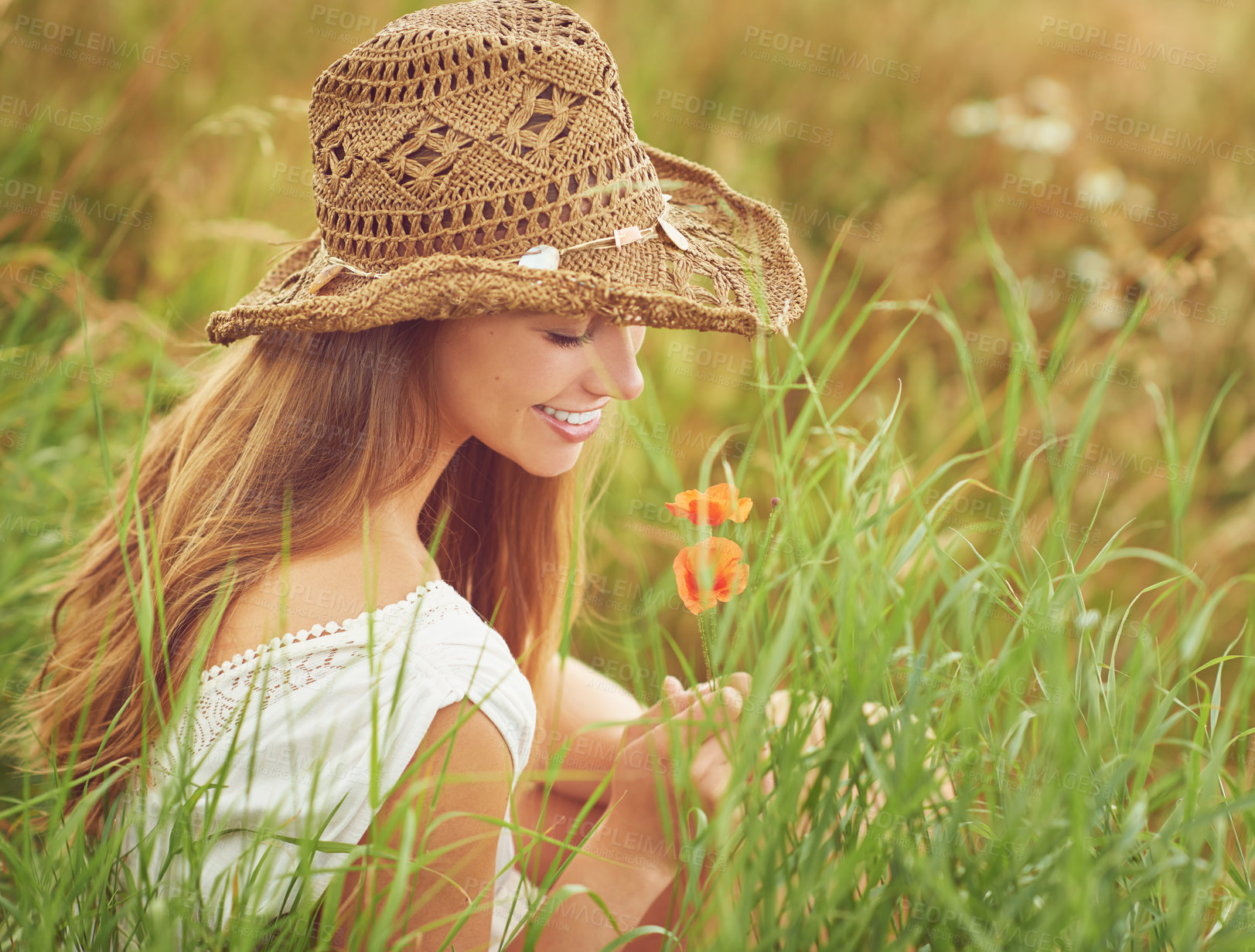 Buy stock photo Shot of a young woman sitting in a field in the countryside