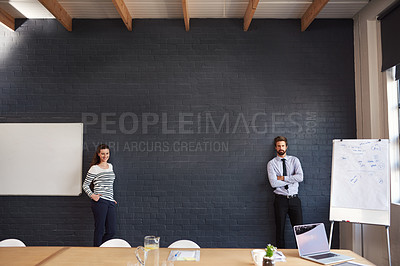 Buy stock photo Portrait of two young businesspeople standing in the boardroom