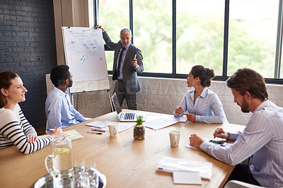 Buy stock photo Shot a mature businessman giving a presentation in the boardroom