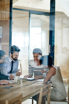 Buy stock photo Through glass shot of a group of colleagues working together in an office