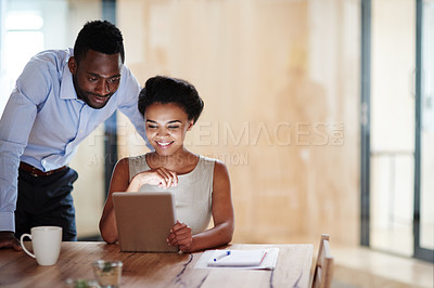Buy stock photo Shot of colleagues using a digital tablet together in an office