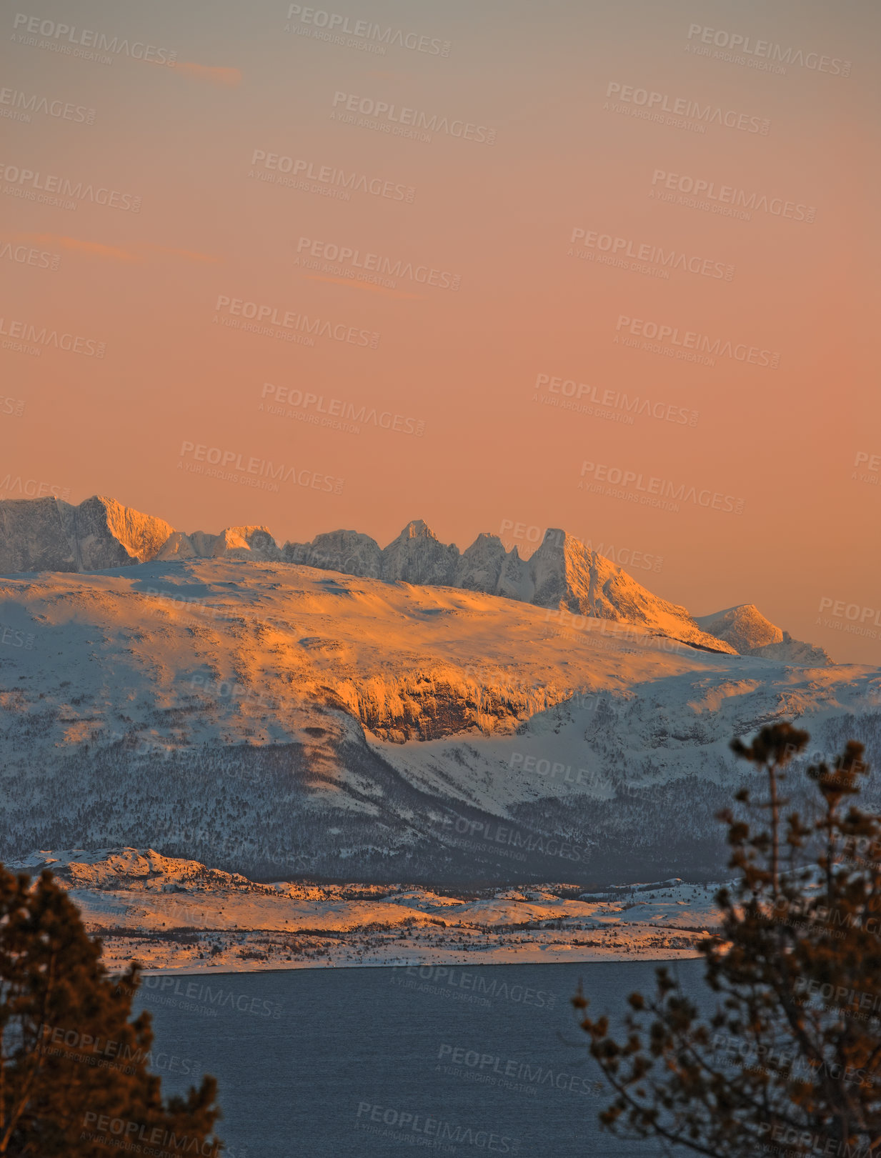 Buy stock photo Landscape view of snow covered land against a sunset background with copyspace.  Bare frosty lands and trees on a field with mountains and hills in the background. A snow blanket covering the ground 