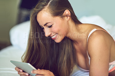 Buy stock photo Shot of a young woman using a digital tablet in her underwear at home