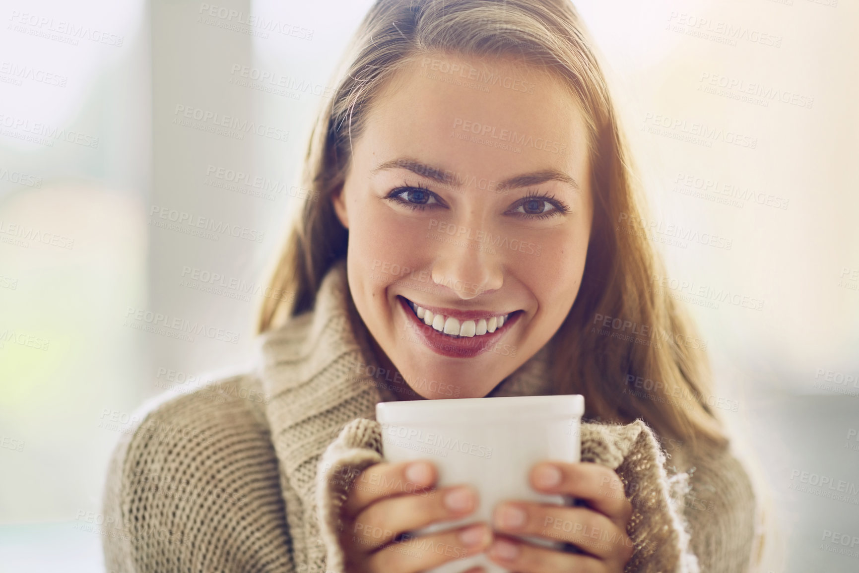 Buy stock photo Portrait of a young woman enjoying a warm beverage at home