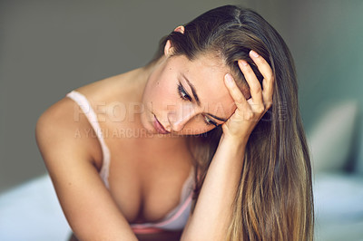 Buy stock photo Shot of a young woman looking depressed at home