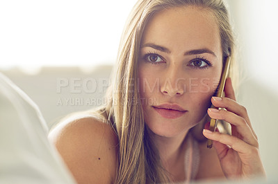 Buy stock photo Shot of a young woman talking on her phone at home