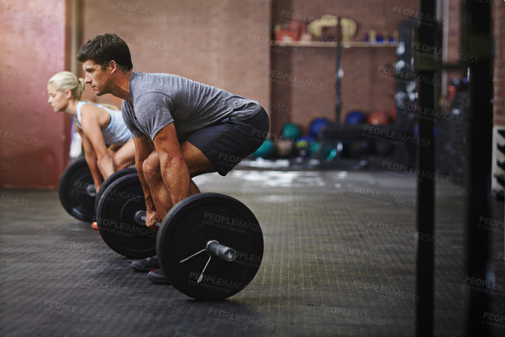 Buy stock photo Shot of two people lifting weights in a gym