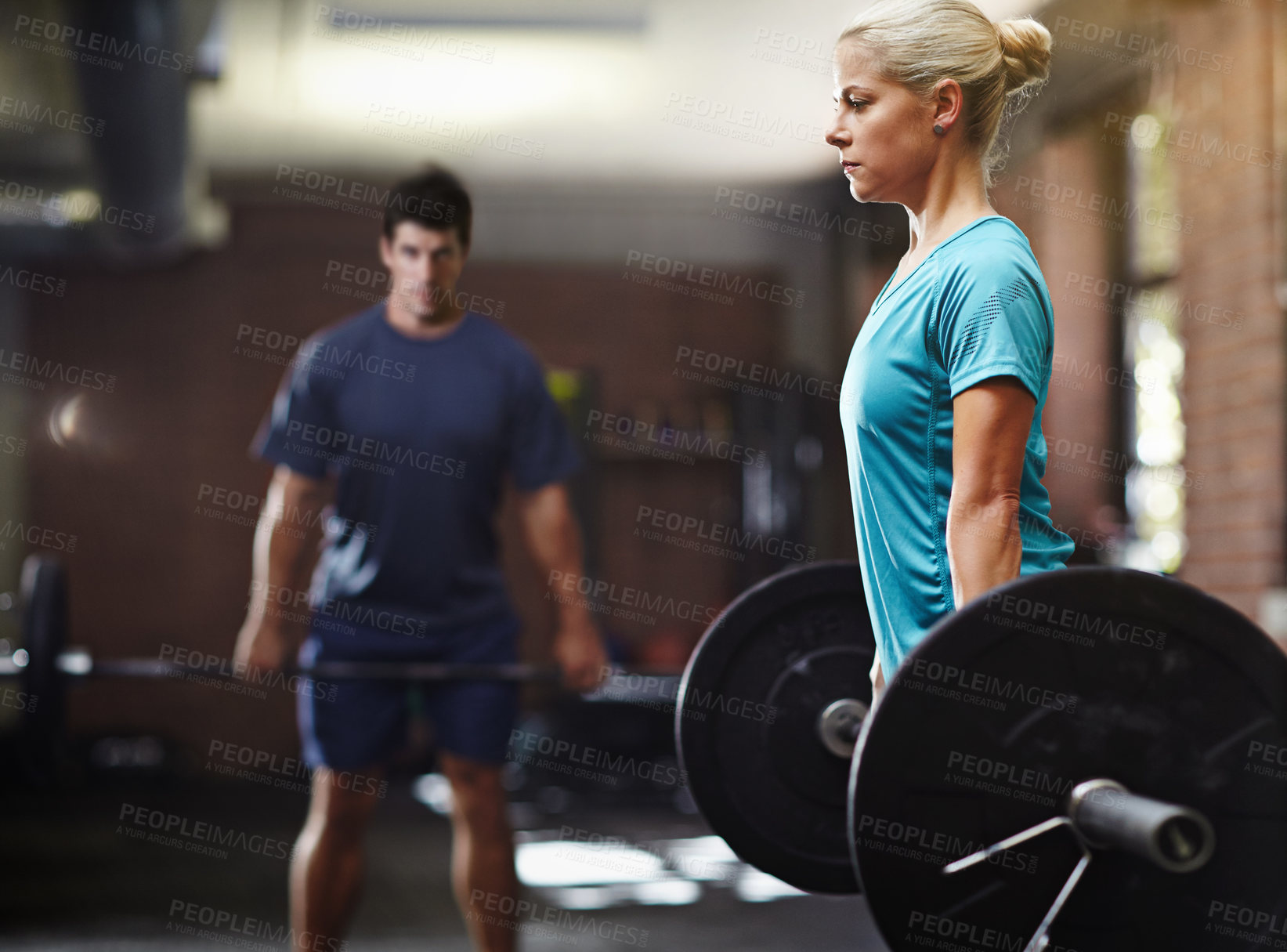 Buy stock photo Shot of two people lifting weights in a gym