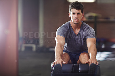 Buy stock photo Shot of a young man doing sit ups in a gym