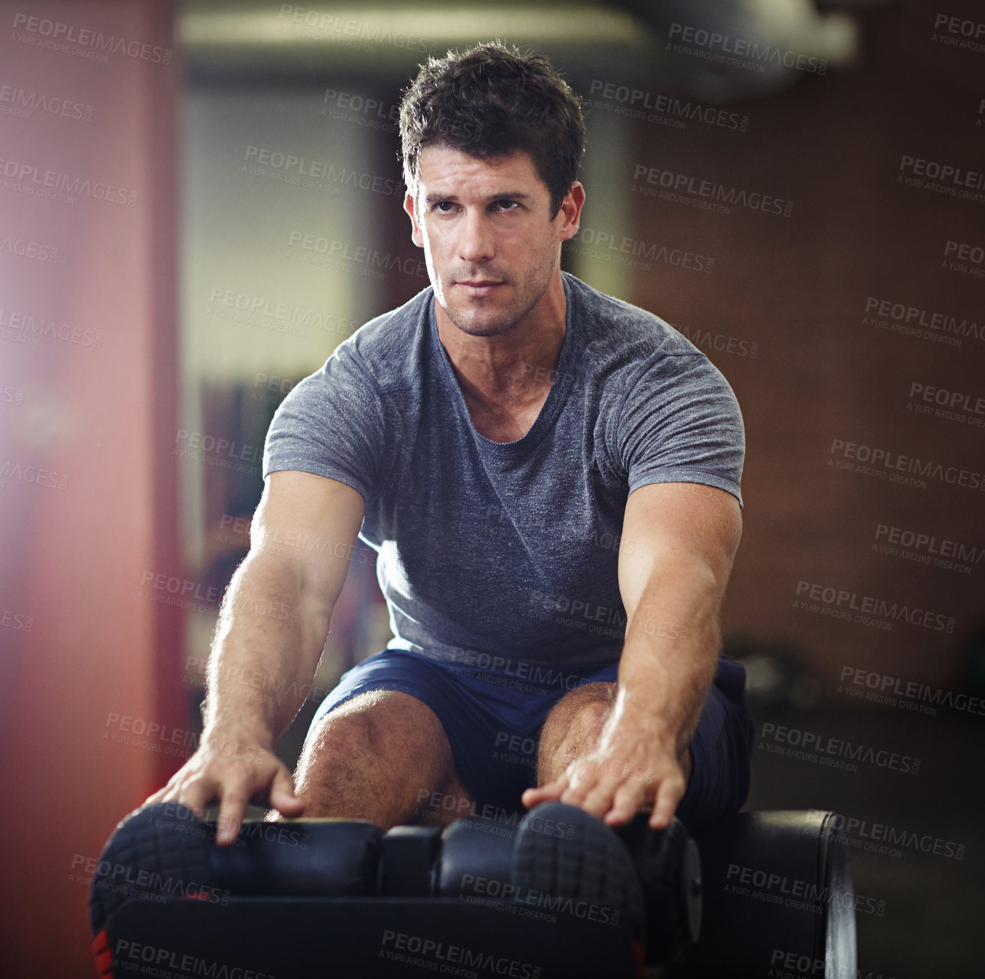 Buy stock photo Shot of a young man doing sit ups in a gym