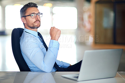 Buy stock photo Shot of a thoughtful businessman using a laptop in the office