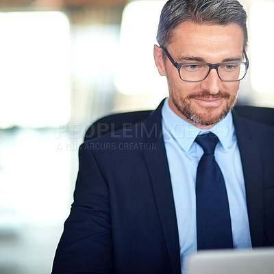 Buy stock photo Shot of a businessman using a laptop in the office