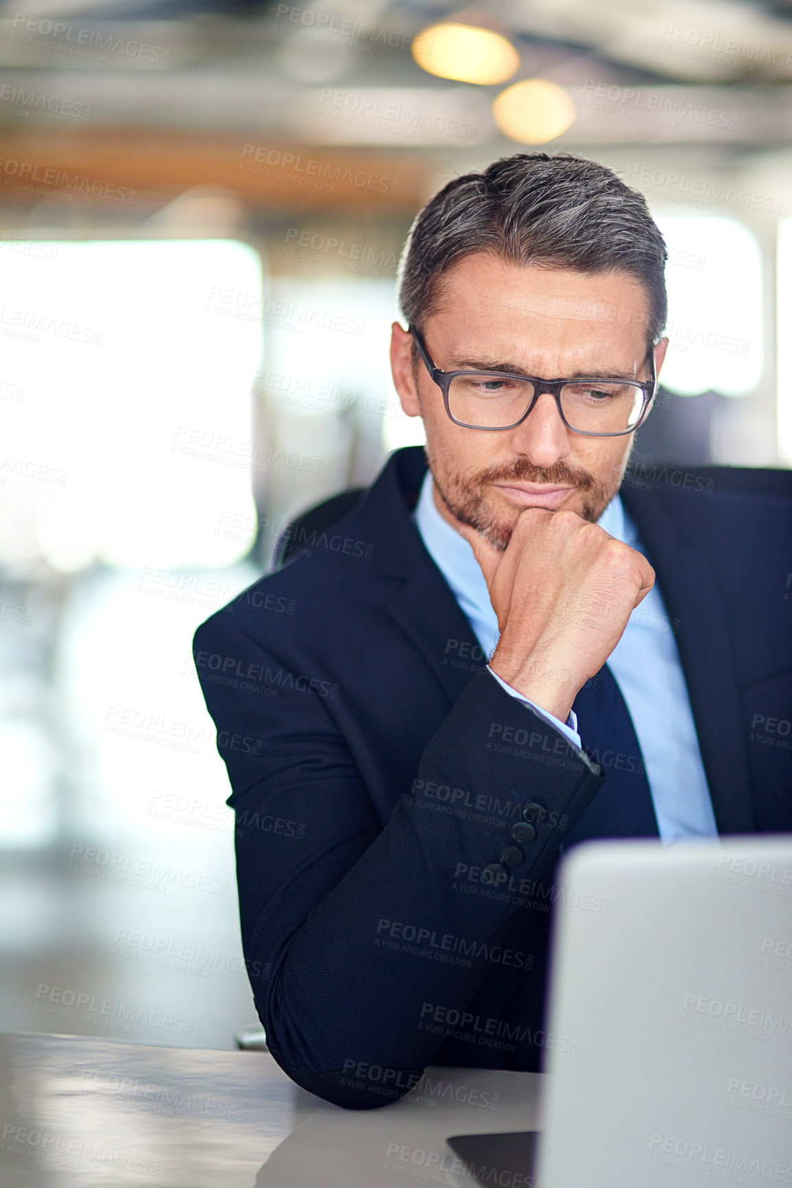 Buy stock photo Shot of a businessman using a laptop in the office