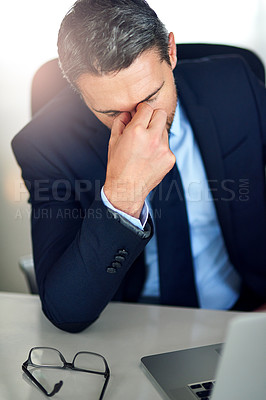 Buy stock photo Shot of a businessman experiencing stress at the office