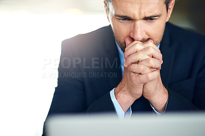 Buy stock photo Shot of a businessman looking anxious in front of his laptop at work