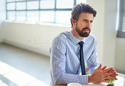 Buy stock photo Cropped shot of a young businessman sitting in his office