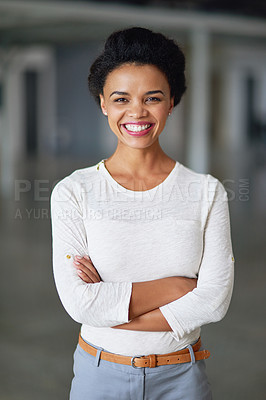 Buy stock photo Cropped portrait of a young businesswoman standing with her arms folded in the office