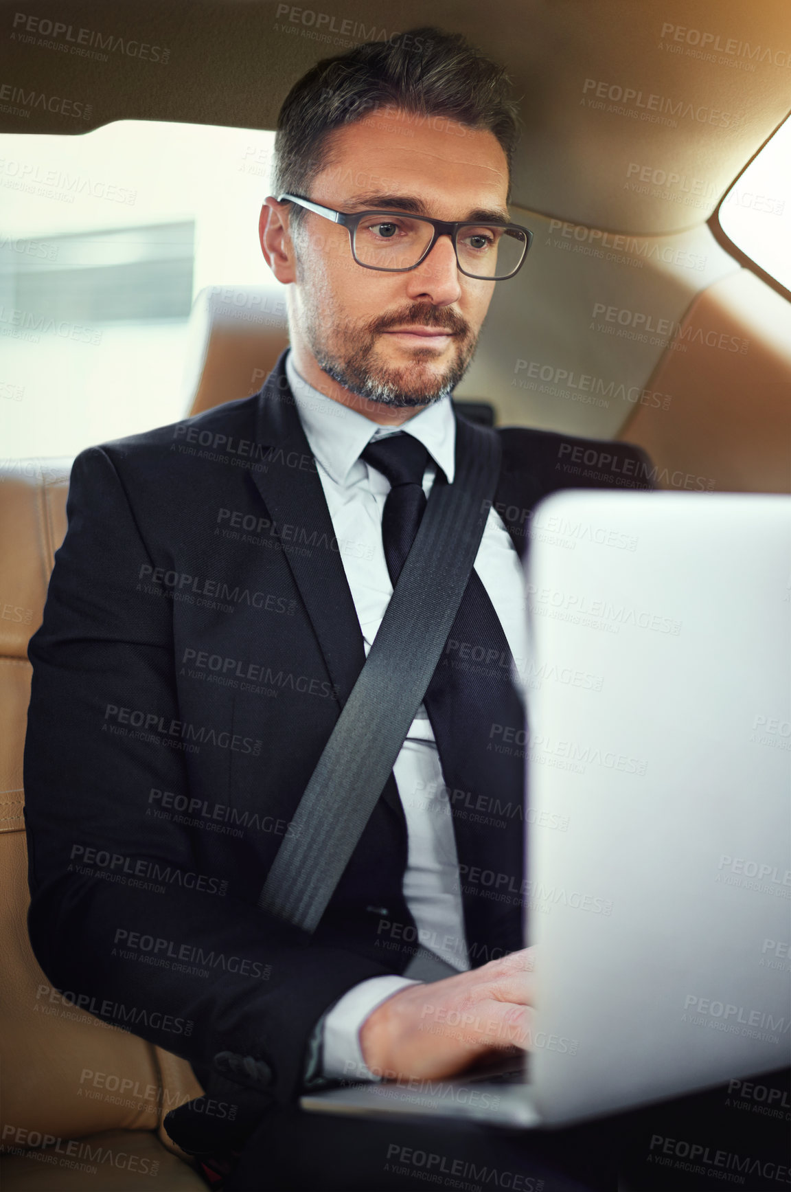 Buy stock photo Cropped shot of a businessman in the backseat of a car