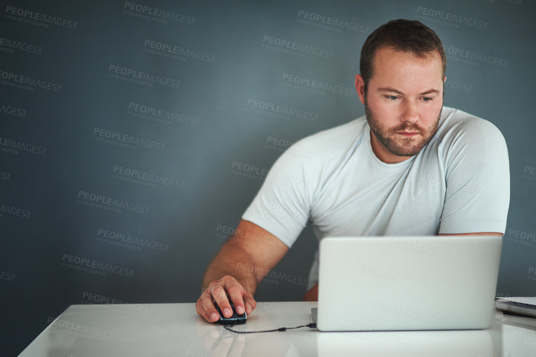 Buy stock photo Cropped shot of a young man working on his laptop