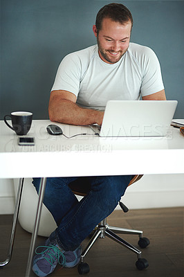 Buy stock photo Full length shot of a young man working on his laptop