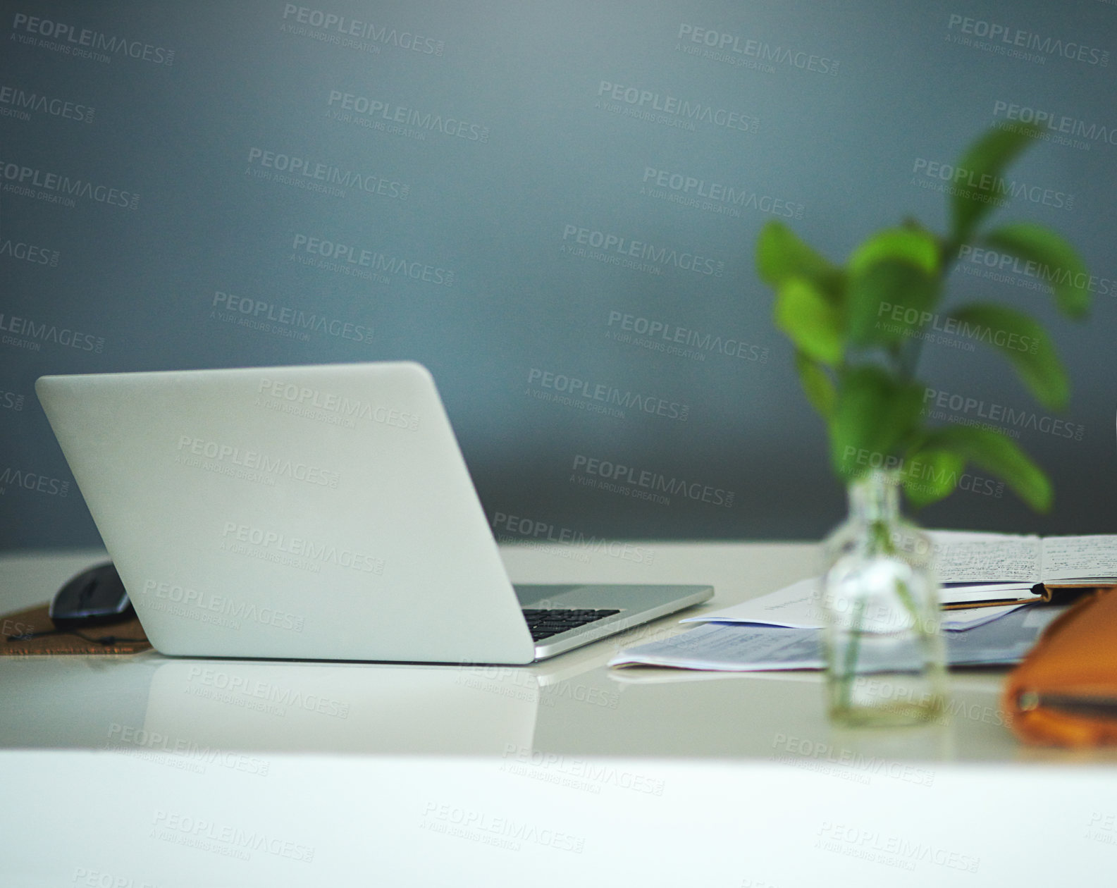 Buy stock photo Shot of a laptop on a desk in a creative business space