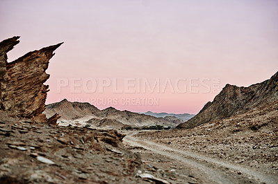 Buy stock photo Shot of a dirt road running through rugged terrain