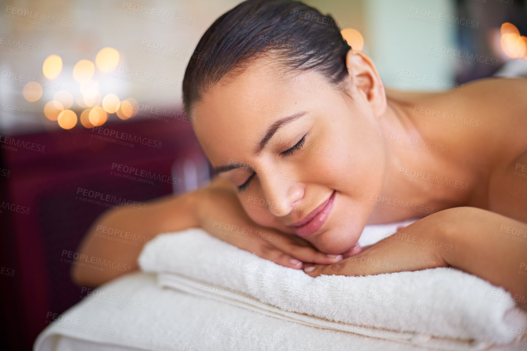 Buy stock photo Spa, woman or relax on bed for peace, wellness or ready for therapeutic massage. Luxury, smile or client at resort for treatment, zen or stress free environment for rest or healing in hospitality