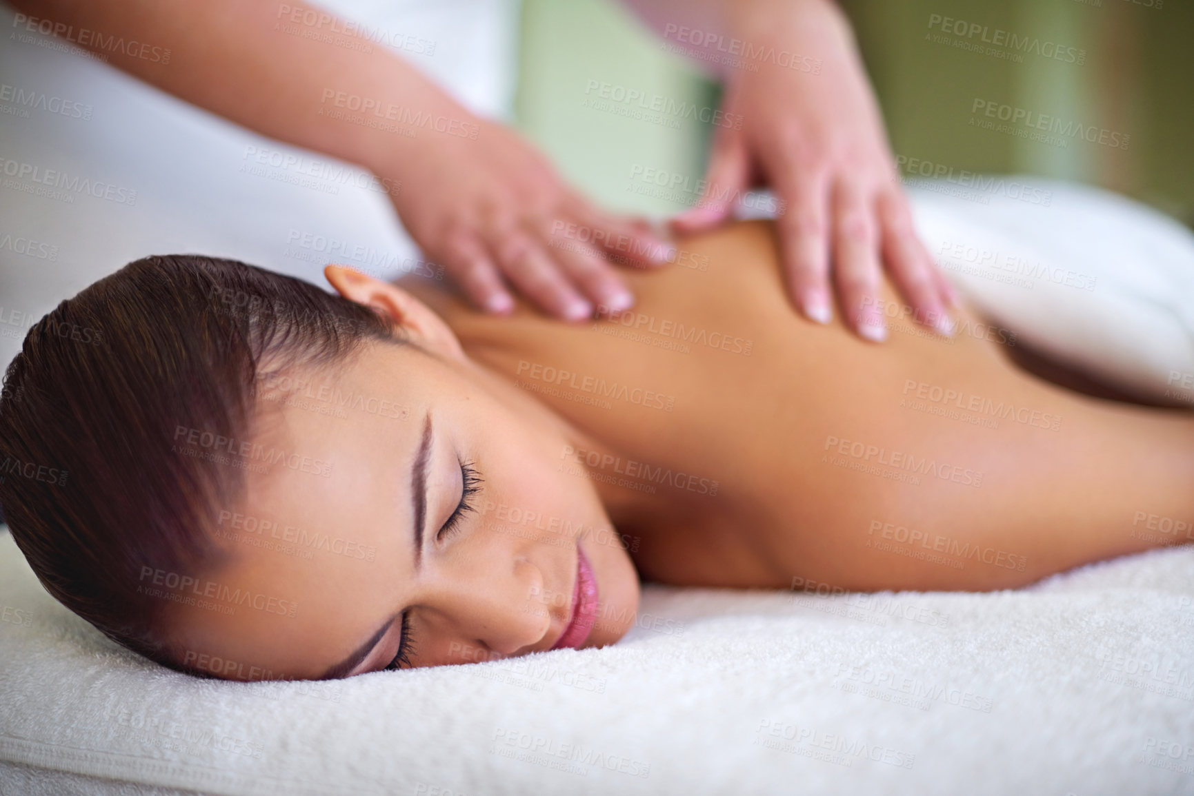 Buy stock photo Shot of a young woman enjoying a back massage at a spa