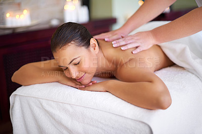 Buy stock photo Shot of a young woman enjoying a back massage at a spa