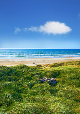 Buy stock photo Ocean, shoreline and island with grass, blue sky or sand for vacation trip and holiday environment. Brazil, outdoor and view of nature, sea and beach in Rio de Janeiro with paradise for calm travel