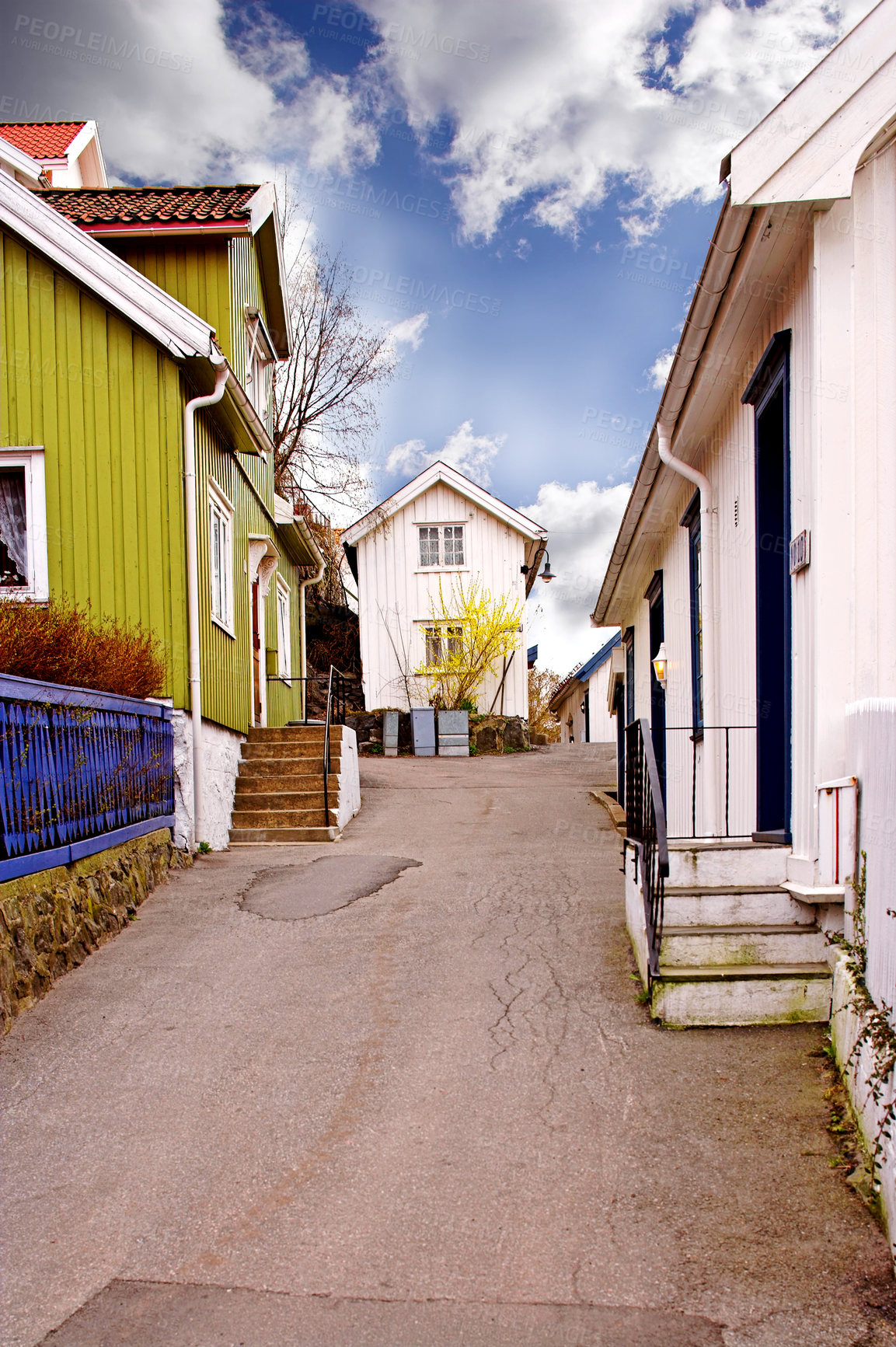 Buy stock photo View of an empty alley or street between houses in a town or city. A narrow tar road through a small overseas village. Exploring an urban suburb as a holiday, tourism, or vacation location in Norway 