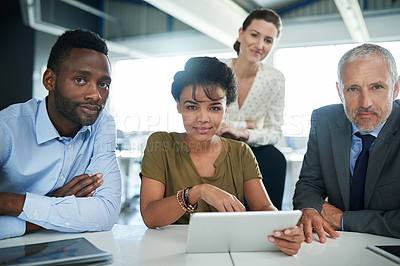Buy stock photo Portrait of a group of businesspeople sitting together in an office using a digital tablet