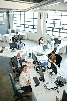 Buy stock photo Portrait of a group of coworkers sitting at their workstations in an office