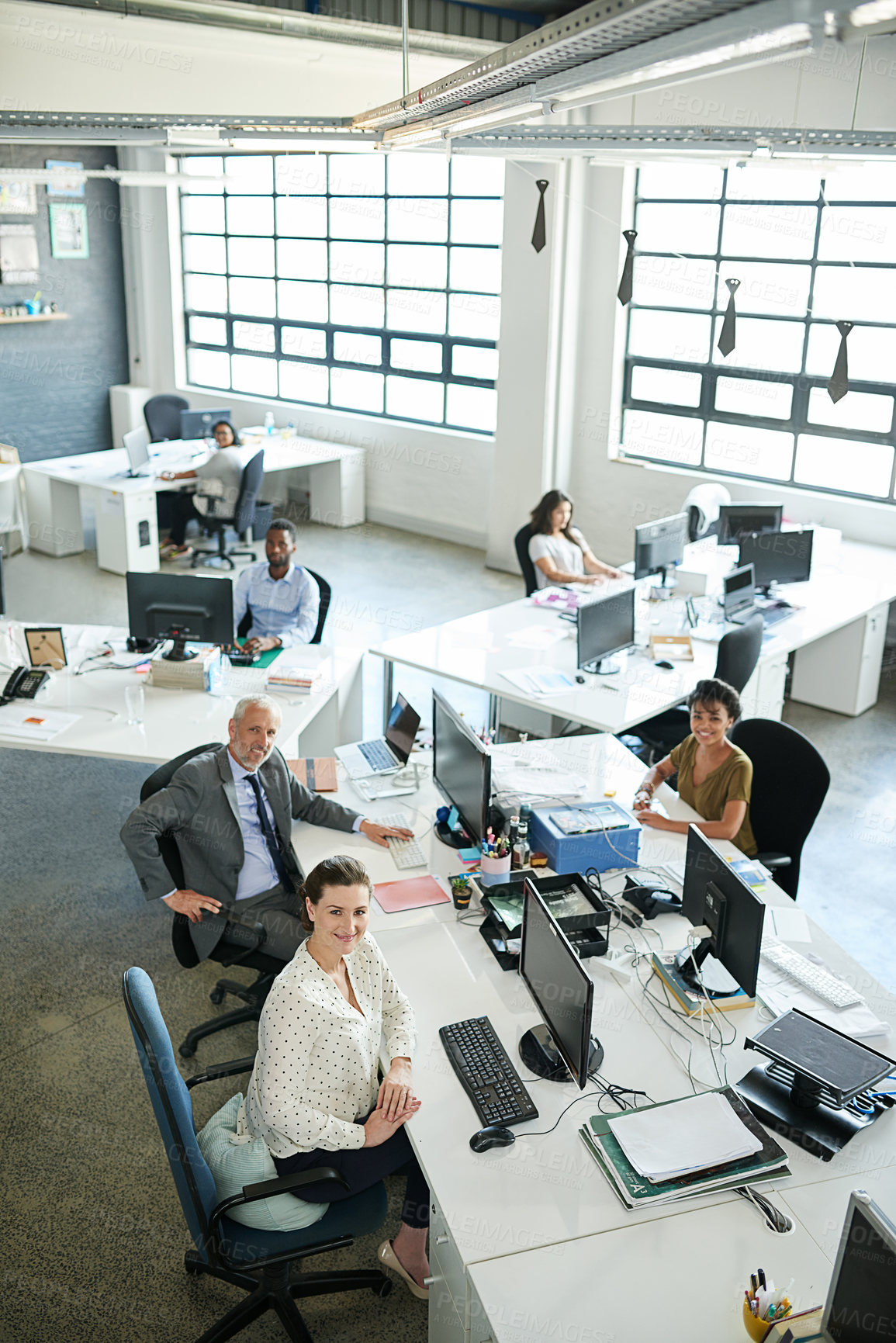 Buy stock photo Portrait of a group of coworkers sitting at their workstations in an office